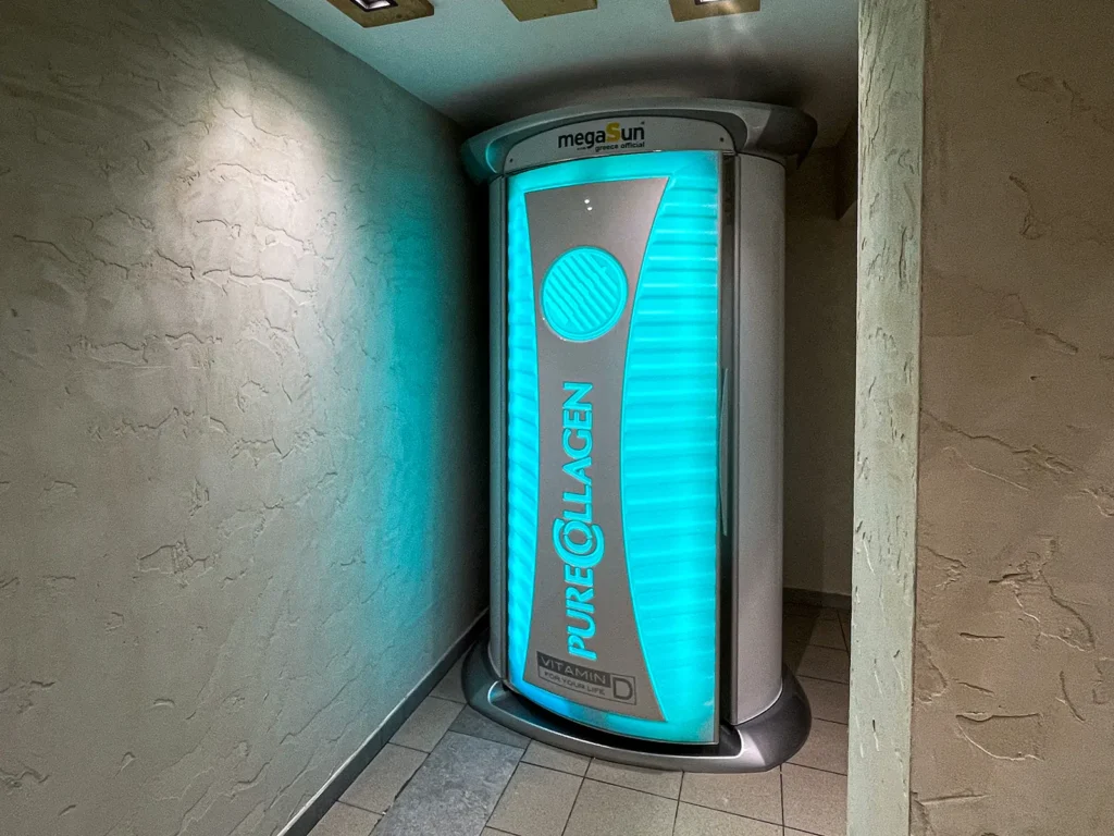 MegaSun Pure Collagen standing solarium illuminated in blue at MegaSun Solarium Larnaca