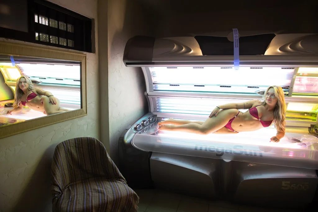Woman using MegaSun 5600 laying solarium inside a private tanning room in Larnaca